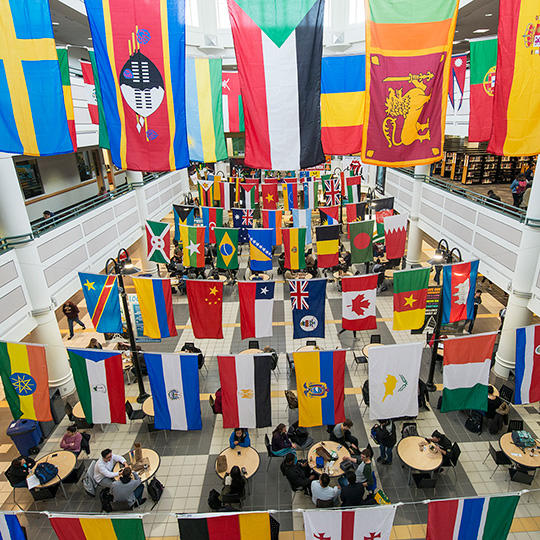 An aerial view of the Johnson Center atrium decorated with hundreds of flags from countries all over the world.